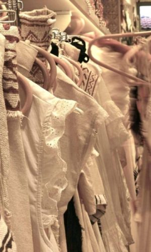 Freshly cleaned white garments hanging on wooden hangers, representing WashBear's premium laundry delivery service